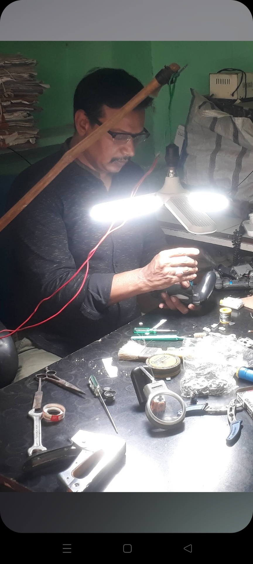 Mohsin bhai repairing a controller at the workshop bench